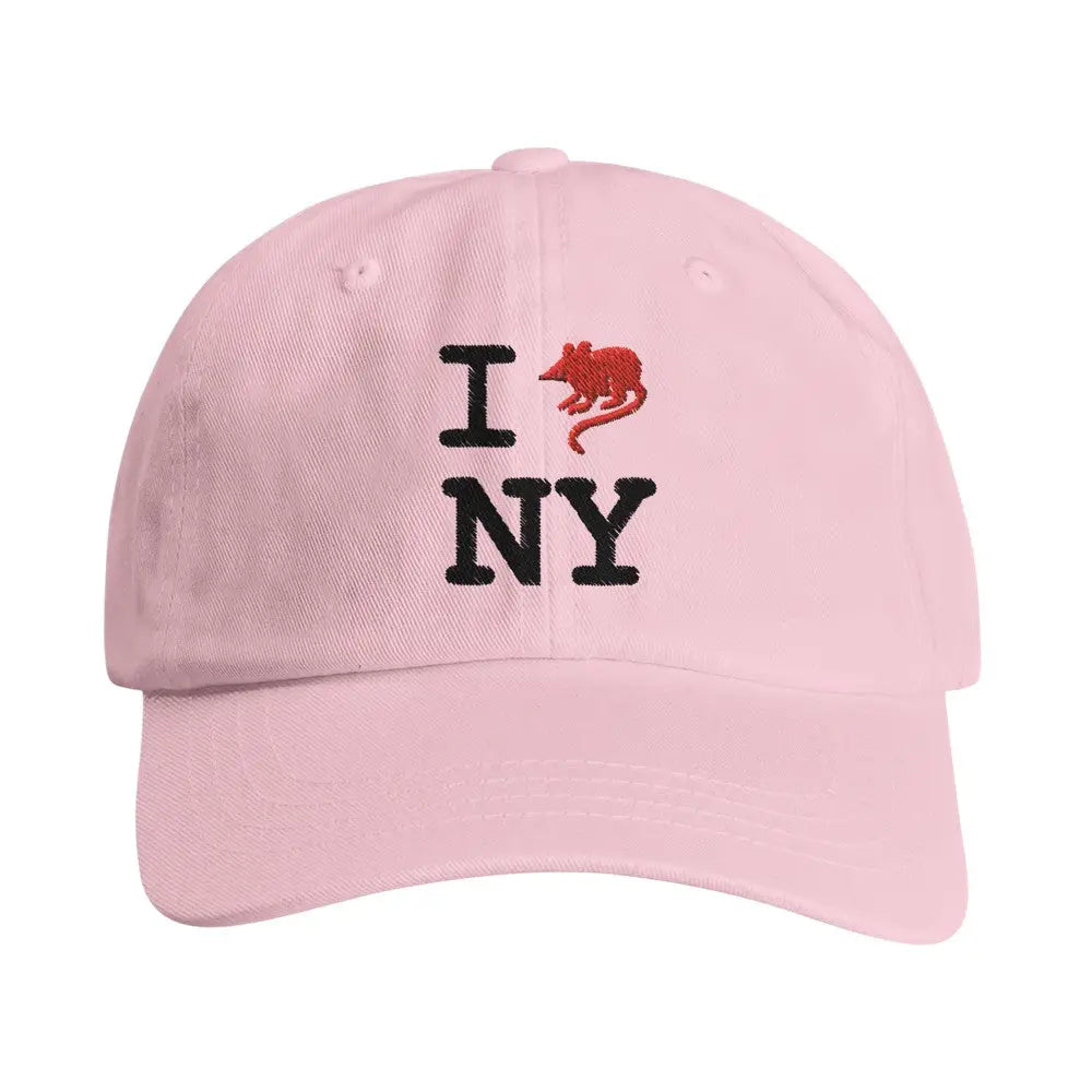 Pink baseball cap with an embroidered design reading "I [rat graphic] NY." The iconic heart symbol is replaced with a red rat, giving a gritty, humorous twist to the classic "I heart NY" logo, reflecting New York City's urban charm and character.