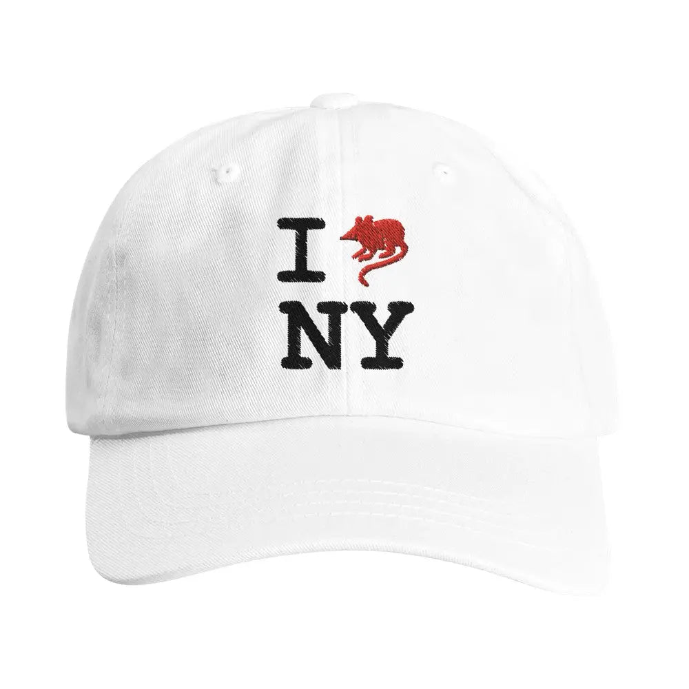 White baseball cap with an embroidered design reading "I [rat graphic] NY." The iconic heart symbol is replaced with a red rat, giving a gritty, humorous twist to the classic "I heart NY" logo, reflecting New York City's urban charm and character.