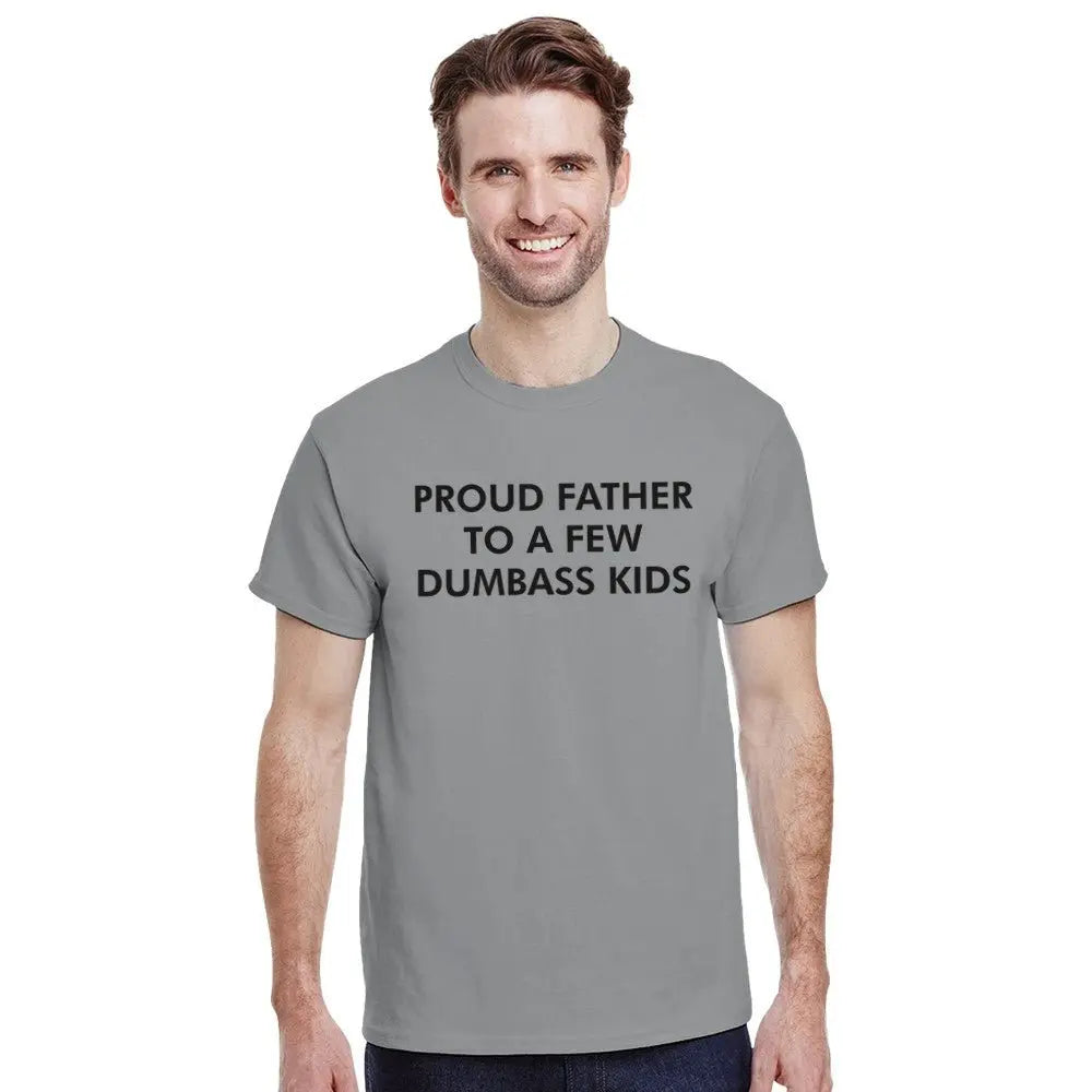 Grey T-shirt with bold white text reading, "PROUD FATHER TO A FEW DUMBASS KIDS." The design humorously conveys a lighthearted, self-deprecating message about parenthood, appealing to dads with a sense of humor about family dynamics.